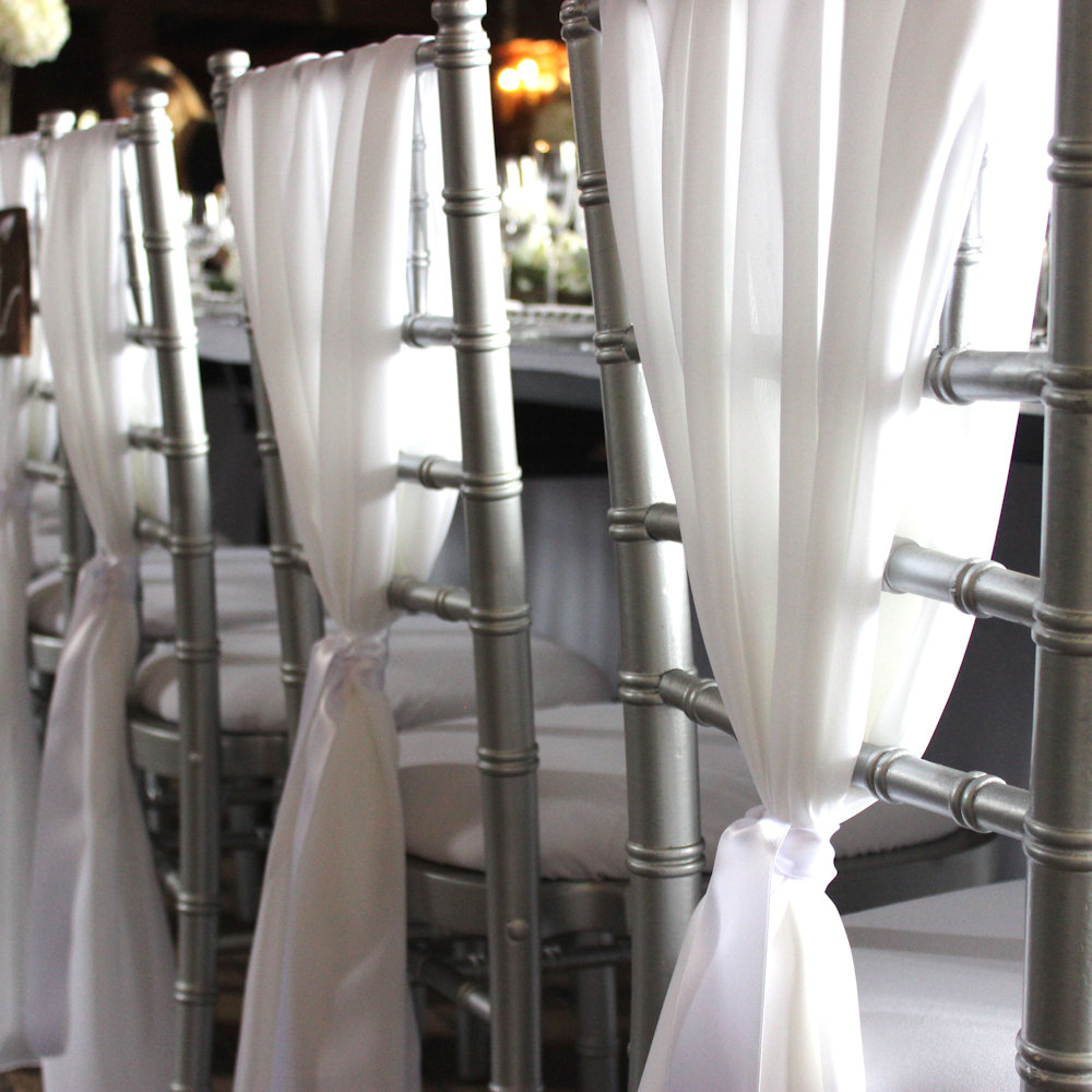 White chiffon drape on silver chiavari chairs