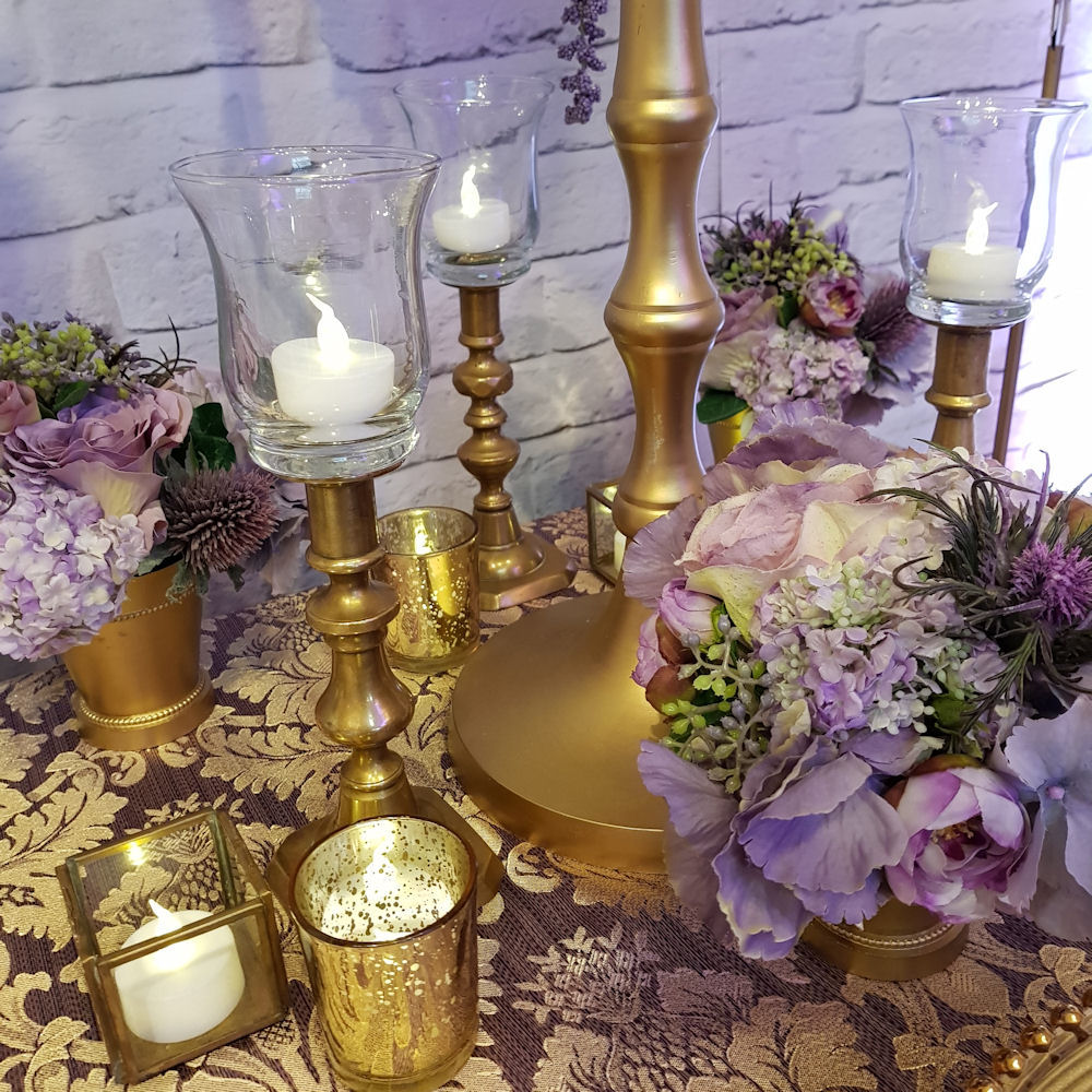 Gold and purple candlesticks charger plates table numbers silk flowers