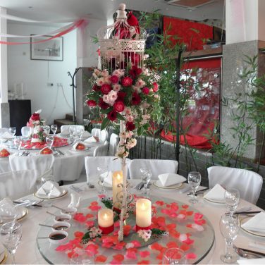 Chinese-Birdcage-on-Tall-Stand-with-Pink-Red-Flowers-Candles-Bird