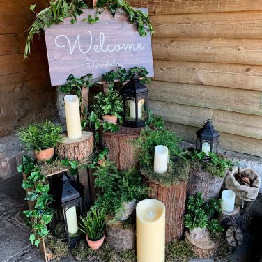 Priory barn log display foliage plants welcome sign led candles lanterns