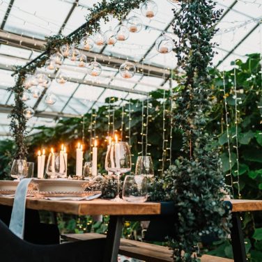 Over table rod with greenery and hanging globes with led tea lights