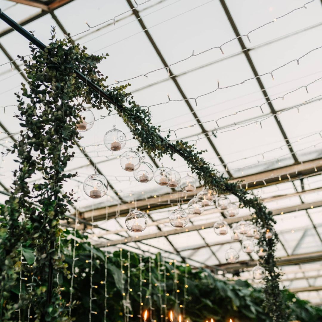 Over table rod with greenery and hanging globes with led tea lights