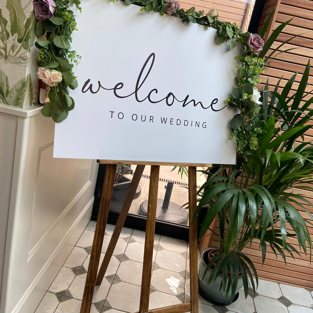 White Welcome Sign with Rustic Easle