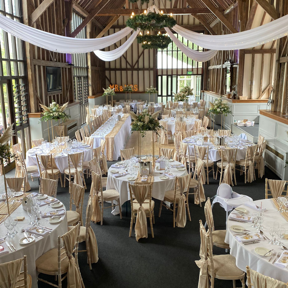 Champagne chair wraps with rectangular stands and cheesecloth runners