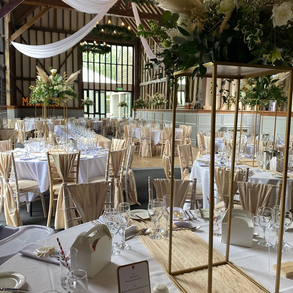 Champagne chair wraps with rectangular stands and cheesecloth runners