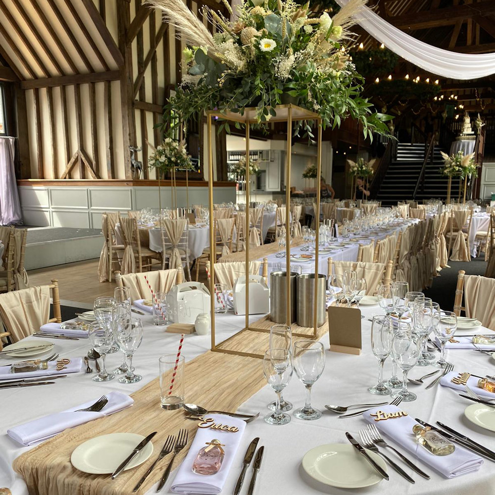 Champagne chair wraps with rectangular stands and cheesecloth runners