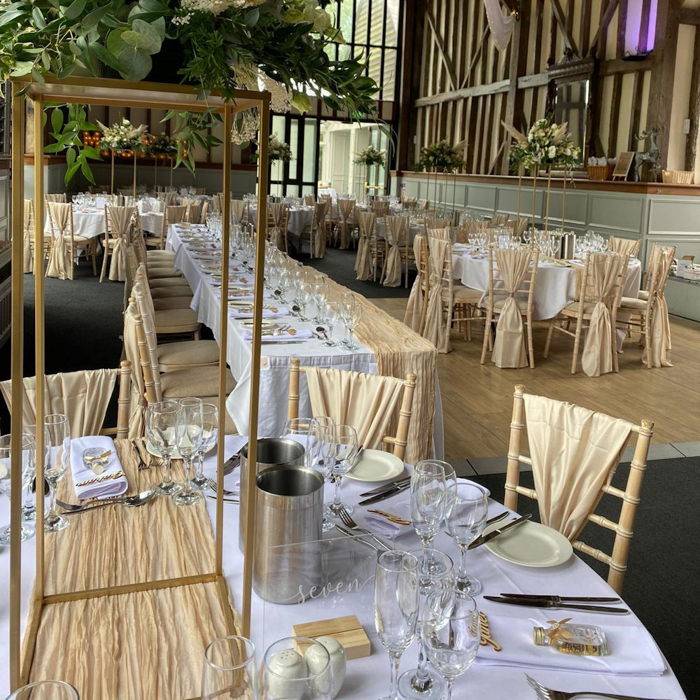 Champagne chair wraps with rectangular stands and cheesecloth runners