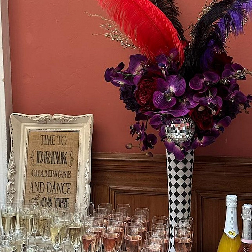 Circus Centrepiece Harlequin Vase with Purple & Red flowers feathers & mirror balls hire rent