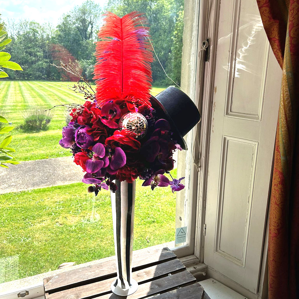 Circus Centrepiece Harlequin Vase with Purple & Red flowers feathers & mirror balls hire rent
